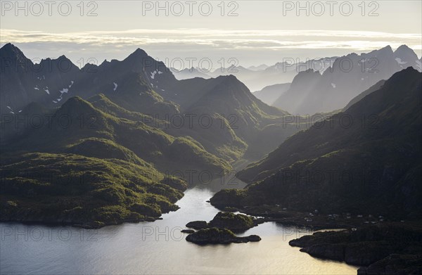Mountains and fjord landscape with atmospheric evening light, Ulvagfjorden fjord and mountains, view from the top of Dronningsvarden or Stortinden, Vesteralen, Norway, Europe