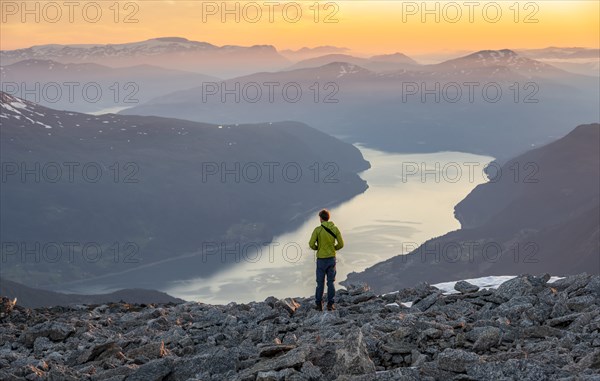 View of mountains and fjord Faleidfjorden, at sunset, mountaineer at the summit of Skala, Loen, Norway, Europe