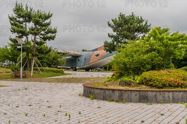 Fairchild C-123K Provider military aircraft on display at museum under cloudy sky in Jeju, South Korea, Asia
