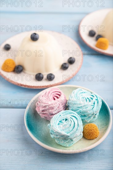White milk jelly with marshmallow on blue wooden background. side view, close up, selective focus