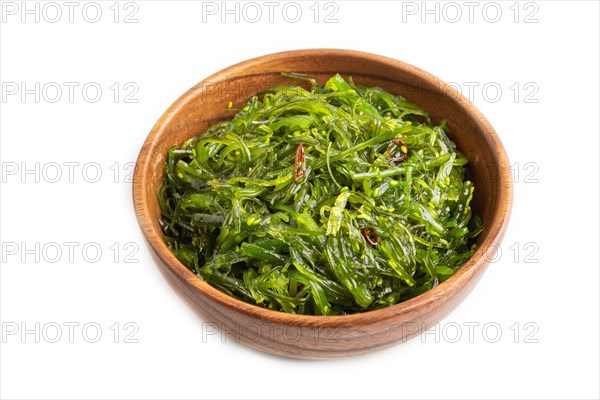 Chuka seaweed salad in brown wooden bowl isolated on white background. Side view