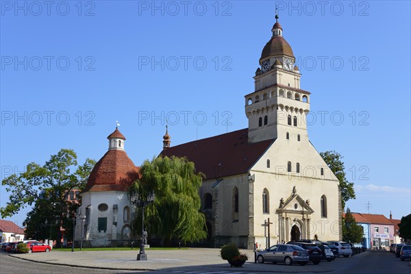 A Gothic church with a striking onion dome under a clear blue sky, St Michael's Roman Catholic Parish Church, Skalica, Skalica, Trnavsky kraj, Slovakia, Europe