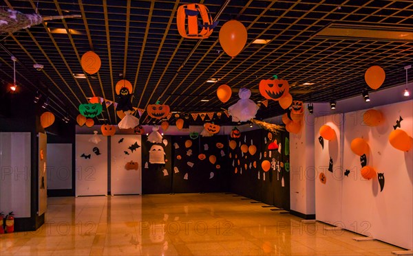 Dimly lit room decorated with hand made Halloween decorations of ghost, jack-o-lanterns and balloons in South Korea