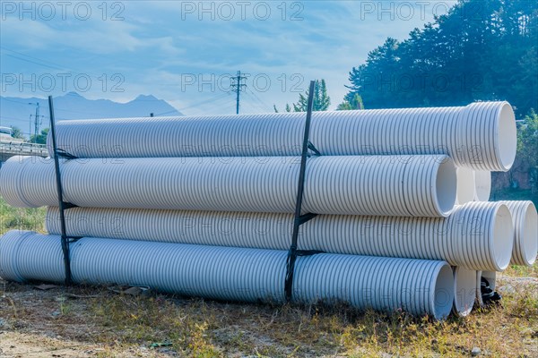 Stack of industrial sewer pipes in rural wilderness park