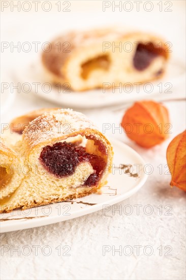 Homemade sweet bun with apricot jam and cup of coffee on gray concrete background. side view, close up, selective focus