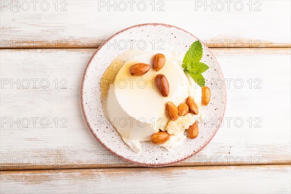 Ricotta cheese with honey and almonds on white wooden background. top view, flat lay, close up