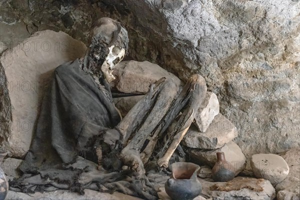 Mummy Salar de Uyuni Bolivia A mummy sits in a cave surrounded by ancient pottery