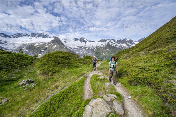Two mountaineers on a hiking trail in a picturesque mountain landscape, mountain peaks with snow and glacier Hornkees and Waxeggkees, summit Grosser Moeseler and Hornspitzen, Berliner Hoehenweg, Zillertal Alps, Tyrol, Austria, Europe