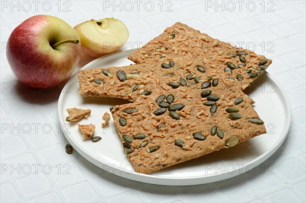 Crispbread with seeds on a plate and apple