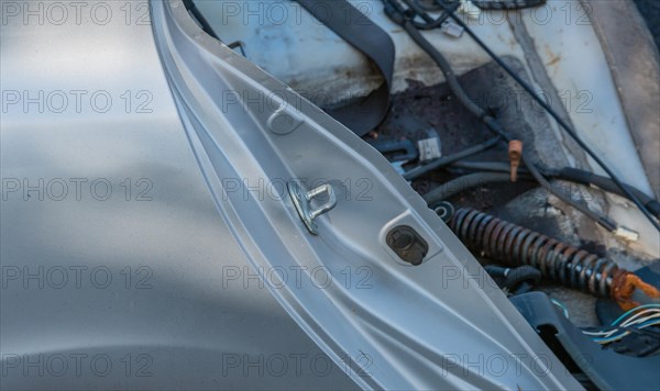 Side view of wreaked car with focus on door catch bracket