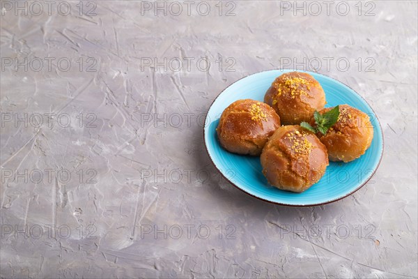 Homemade traditional turkish dessert sekerpare with almonds and honey on gray concrete background. side view, copy space