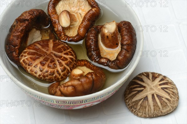 Dried shiitake mushrooms in a bowl, soaked in water