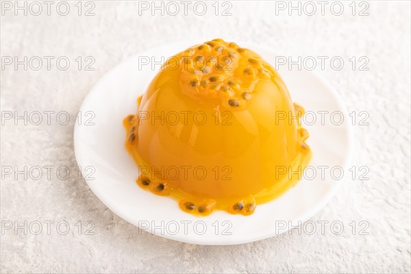 Mango and passion fruit jelly on gray concrete background. side view, close up