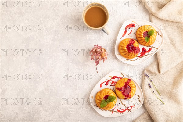 Semolina cheesecake with strawberry jam, lavender, cup of coffee on gray concrete background and linen textile. top view, flat lay, copy space