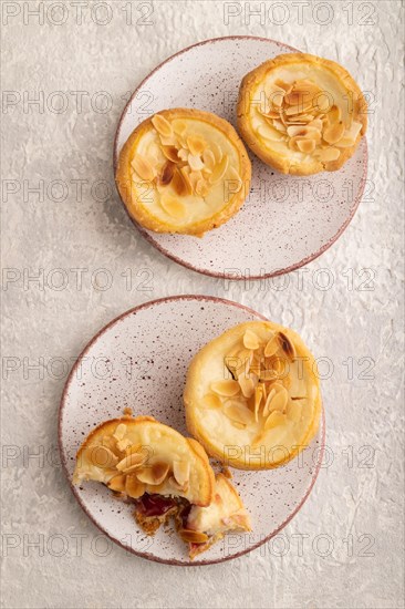 Traditional portuguese cakes pasteis de nata, custard small pies with almonds on gray concrete background. Top view, flat lay, close up