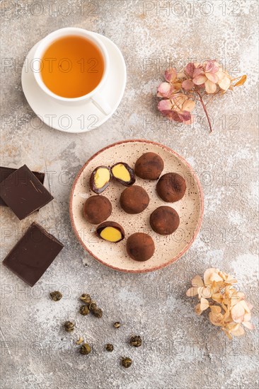 Japanese rice sweet buns chocolate mochi filled with cream and cup of green tea on brown concrete background. top view, flat lay, close up