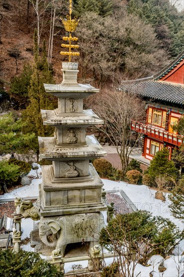 Four story stone carved pagoda on plinth of three elephants at Buddhist temple in South Korea