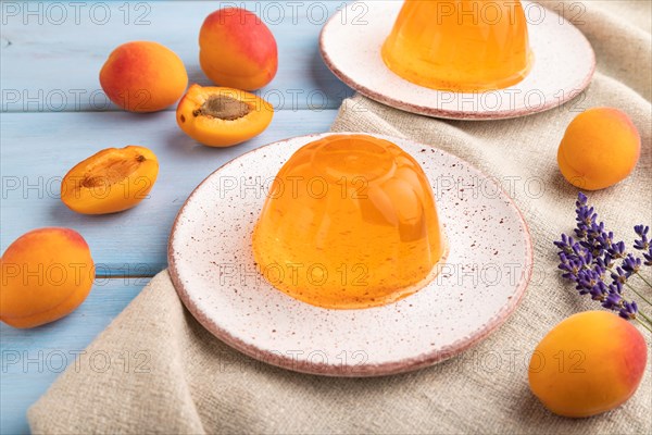 Apricot orange jelly on blue wooden background and linen textile. side view, close up