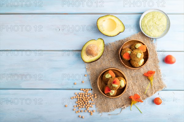 Falafel with guacamole on blue wooden background and linen textile. Top view, flat lay, copy space