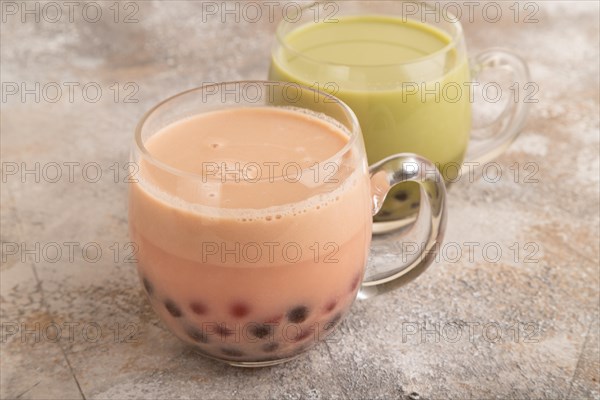 Bubble tea with pistachio and caramel in glass on brown concrete background. Healthy drink concept. Side view, close up