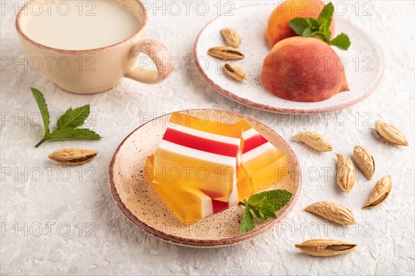 Almond milk and peach jelly on gray concrete background. side view, close up