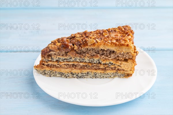 Walnut and hazelnut cake with caramel cream on blue wooden background. side view, close up
