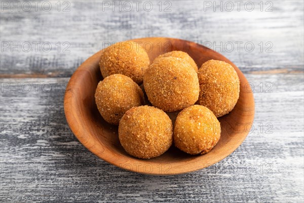 Meat balls on a wooden plate on a gray wooden background. Side view, close up