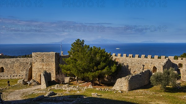 Sunny view of an old fortress with green trees and a blue sky with light clouds, Chlemoutsi, High Medieval Crusader Castle, Kyllini Peninsula, Peloponnese, Greece, Europe