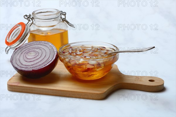 Honey in a jar and chopped onion as ingredients for cough syrup