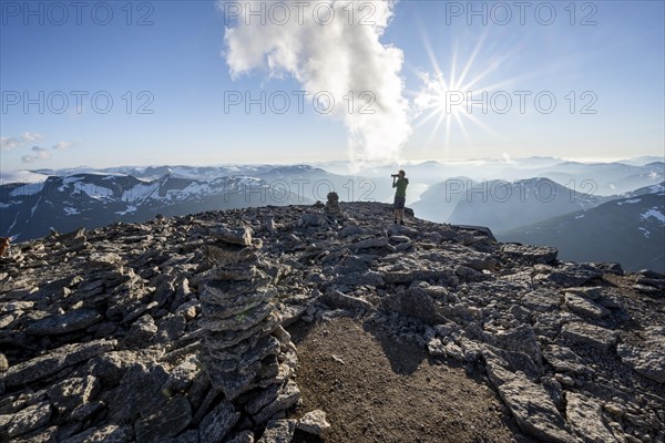 Mountaineers photographed, at the summit of Skala with cairns, view of mountain landscape and fjord Faleidfjorden, Sun Star, Loen, Norway, Europe