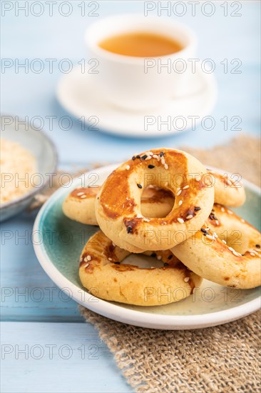 Homemade asian salted cookies, cup of green tea on blue wooden background and linen textile. side view, close up, selective focus