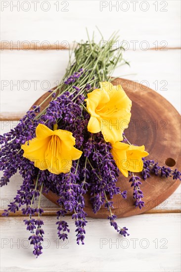 Beautiful day lily and lavender flowers on white wooden background, side view, close up