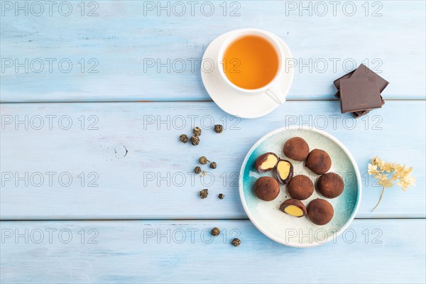Japanese rice sweet buns chocolate mochi filled with cream and cup of green tea on blue wooden background. top view, flat lay, copy space