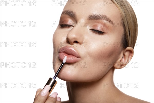 Beauty portrait of model with natural make-up holding a jar of cream. Fashion shiny highlighter on skin, sexy gloss lips make-up High quality photo. Holds lipstick