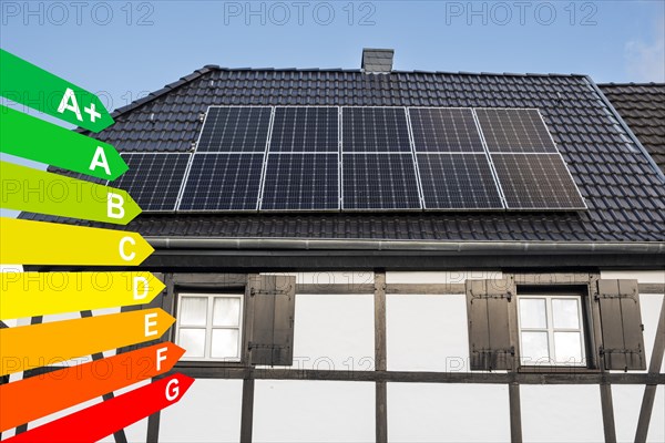 Solar panel on the roof of a half-timbered house, graphic with energy efficiency classes for buildings according to the GEG, Duesseldorf, North Rhine-Westphalia, Germany, energy efficiency, Europe