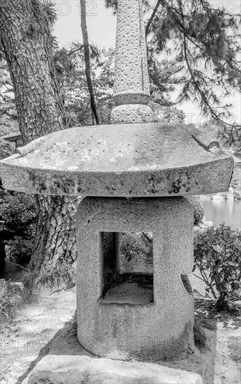 Black and white closeup of large stone lantern in Shukkeien gardens in Hiroshima, Japan, Asia