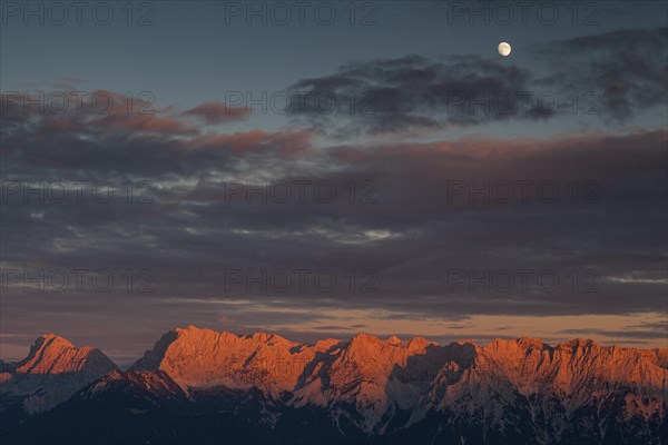 Distant view of steep mountains in the evening light, clouds, autumn, moon, view from Wank to Karwendel mountains, Werdenfelser Land, Upper Bavaria, Bavaria, Germany, Europe