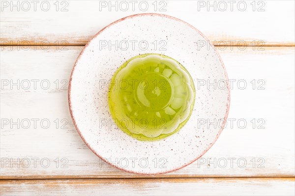 Mint green jelly on white wooden background. top view, flat lay, close up
