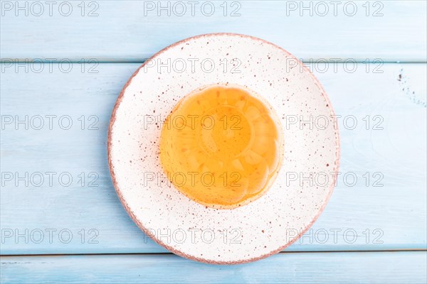 Apricot orange jelly on blue wooden background. top view, flat lay, close up