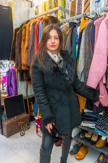 Vertical portrait of a stylish beauty woman looking at camera while shopping during sales