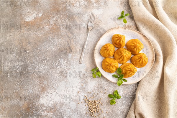 Fried manti dumplings with pepper, basil on gray concrete background and linen textile. Top view, flat lay, copy space