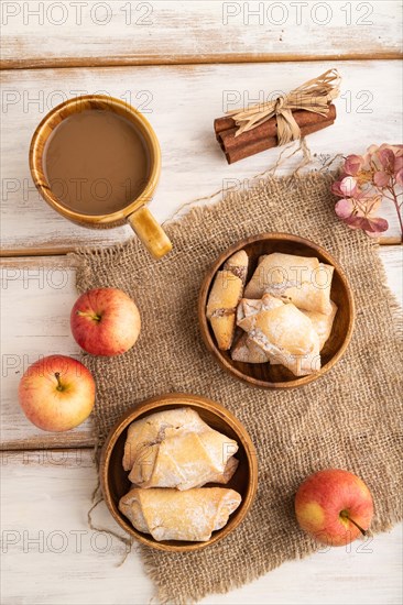 Homemade sweet cookie with apple jam and cup of coffee on white wooden background and linen textile. top view, flat lay, close up