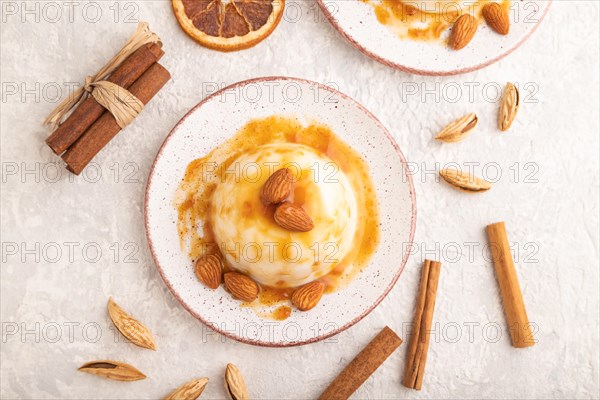 White milk jelly with caramel sauce on gray concrete background. top view, flat lay