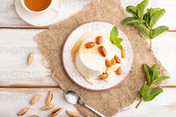 Ricotta cheese with honey and almonds on white wooden background and linen textile. top view, flat lay, close up