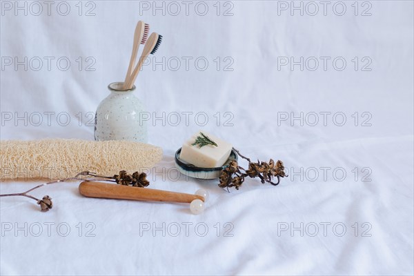 Eco-friendly personal care items with toothbrushes and soap dish on a white background, conveying a minimalistic and natural vibe