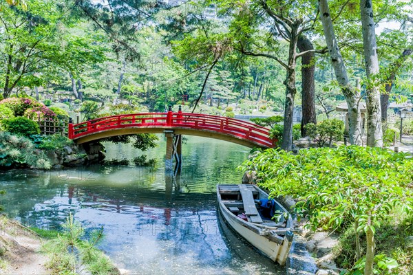 Wooden row boat at shore of lake in Japanese Shukkeien Gardens in Hiroshima, Japan, Asia