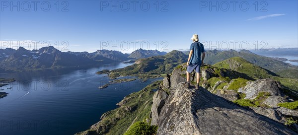 Mountaineer on the summit of Dronningsvarden or Stortinden, mountains and fjord Raftsund, Sonnenstern, Vesteralen, Norway, Europe