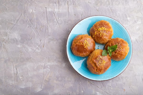 Homemade traditional turkish dessert sekerpare with almonds and honey on gray concrete background. top view, flat lay, copy space