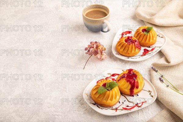 Semolina cheesecake with strawberry jam, lavender, cup of coffee on gray concrete background and linen textile. side view, copy space