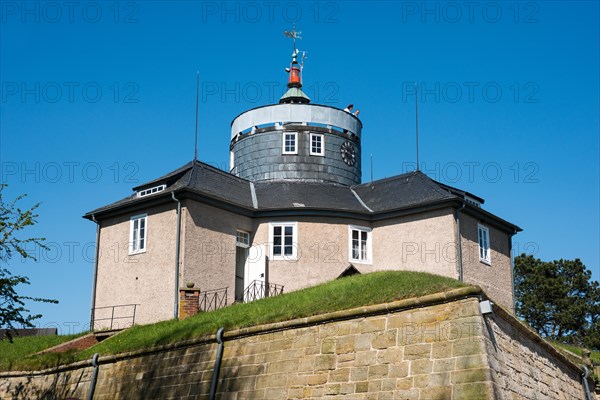 Wilhelmstein Fortress, historic castle with tower, tower clock and weather vane under a clear blue, cloudless sky surrounded by green grass, two tourists enjoying the view, spring, May, artificial island Wilhelmstein in the Steinhuder Meer, Steinhuder Meer nature park Park, Lower Saxony, Germany, Europe